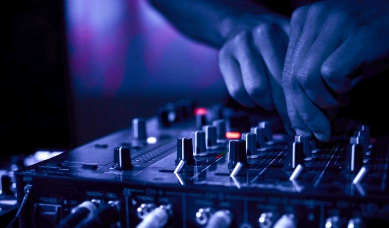 DJ Twisting Knobs On A DJ Mixer